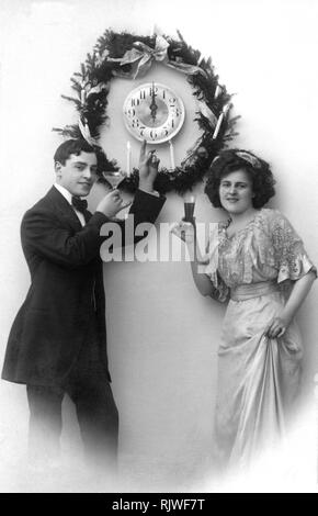 Couple célèbre le Nouvel An, l'horloge indique 24 heures, ca. Années 1910, Allemagne Banque D'Images