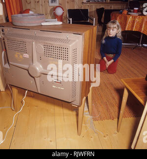 La télévision dans les années 1960. Une fille est assise devant un téléviseur avec ses yeux sur l'écran et le programme. Suède 1969 Banque D'Images