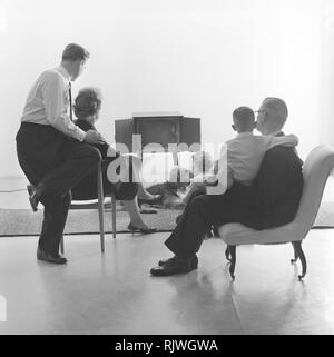 La télévision dans les années 1950. Famille devant un téléviseur et fasciné par le nouveau moyen de la télévision en mars 1959. La Suède Banque D'Images