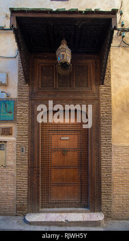 Conception de style traditionnel marocain d'une ancienne porte d'entrée en bois. Dans l'ancienne médina de Fès, Maroc. Ancienne porte de riad, finement sculptée, piqué Banque D'Images