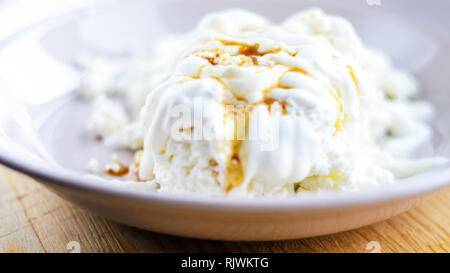 Le fromage cottage blanc avec le caramel. Dessert avec du fromage blanc, de crème et de caramel Banque D'Images