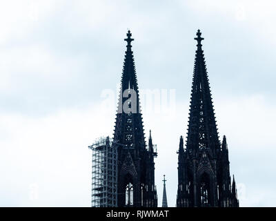 Coup du gothique minimaliste de la cathédrale de Cologne en Allemagne avec l'échafaudage contre ciel nuageux Banque D'Images