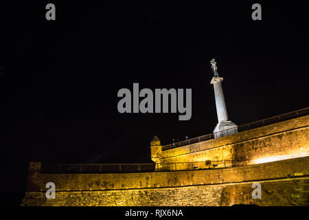 BELGRADE, SERBIE - 31 octobre 2014 : Victor statue sur la forteresse de Kalemegdan vu depuis le parc de Kalemegdan lors d'une soirée sombre, avec les touristes, je pose Banque D'Images