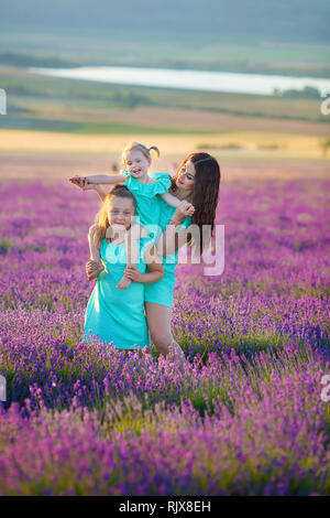 Belle Famille de jolies filles profitez avec girl power sur sunset prairie de lavande. Balade maman et ses filles dans le champ de lavande Banque D'Images