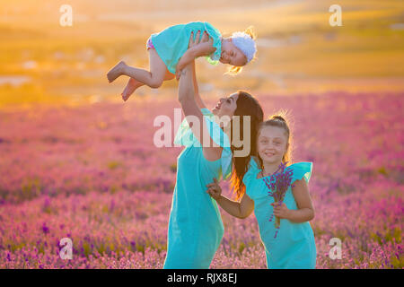 Belle Famille de jolies filles profitez avec girl power sur sunset prairie de lavande. Balade maman et ses filles dans le champ de lavande Banque D'Images