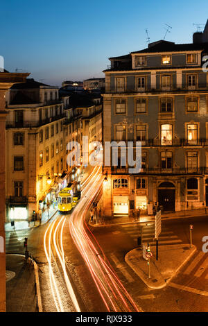 Tramway de Lisbonne à l'aube dans la belle rue avec les maisons historiques et le bleu ciel de nuit. Banque D'Images