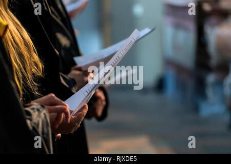 Choristes holding partition de musique et de chant sur les diplômes à l'université, collège début Banque D'Images