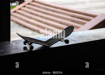 Silhouette of a broken skateboard à côté des escaliers Banque D'Images