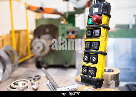 Boutons de commande à distance de la grue jaune en cas sur le fil. Machine de tour est flou en arrière-plan Banque D'Images