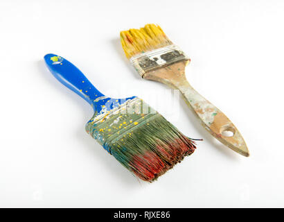 Deux vieux utilisé pinceaux en bois colorées avec de la peinture rouge et jaune sur un fond blanc dans un concept de décoration et bricolage Banque D'Images