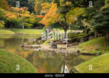 Feuillage de l'automne autour d'un lac dans le jardin Koishikawa Korakuen à Tokyo, Honshu, Japan Banque D'Images