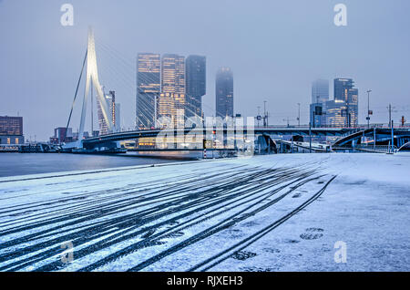 Rotterdam, Pays-Bas, le 1 février 2019 : le vélo dans la neige fraîchement tombée sur un froid matin d'hiver avec le southbank highrise et Erasmus b Banque D'Images