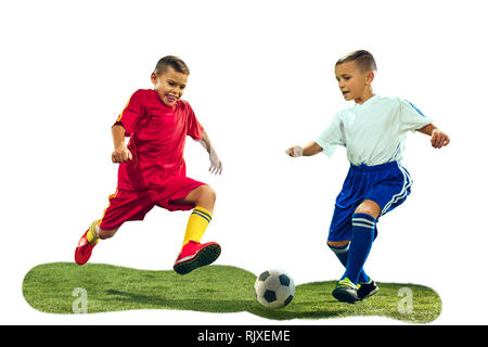 Les jeunes garçons lance le ballon de soccer. Photo isolé sur fond blanc. Les joueurs de football en mouvement sur fond de studio. Mettre en place les garçons en action, saut, mouvement à jeu. Banque D'Images