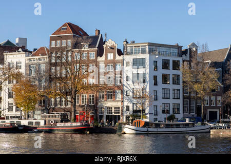 Canal typique des maisons dans le vieux centre-ville d'Amsterdam avec maisons statique reflétant dans le canal et les bateaux devant la maison Banque D'Images