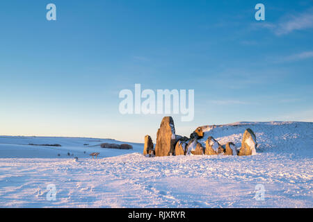 West Kennet Long Barrow dans la neige de l'hiver au lever du soleil. Chambré néolithique tombe. West Kennet, Wiltshire, Angleterre. Banque D'Images