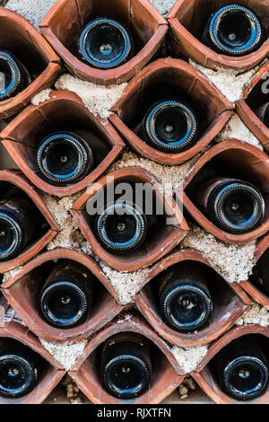 Les bouteilles de vin stocké dans une maison faite en dehors d'un petit stockage primitive maison de village Banque D'Images