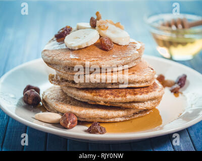 Crêpes de blé entier avec de la banane fraîche ,raisin et noix, miel . Américain d'origine des crêpes au sirop d'érable. petit-déjeuner sain avec des fruits et noix Banque D'Images