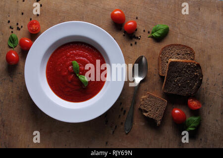 Plaque avec de savoureux soupe de tomate au basilic Banque D'Images