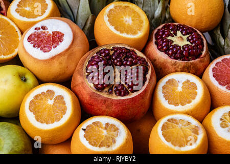 Les grenades et les oranges éventrés pour affichage sur sale at market Banque D'Images