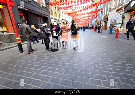Londres, Angleterre, Royaume-Uni. Gerrard Street, Chinatown. Groupe de personnes visiter autour de Nouvel An chinois Banque D'Images