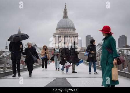 Les touristes bravent les forts vents et la pluie sur le pont du millénaire au centre de Londres, que Storm Erik a de forts vents à certaines parties du pays. Banque D'Images