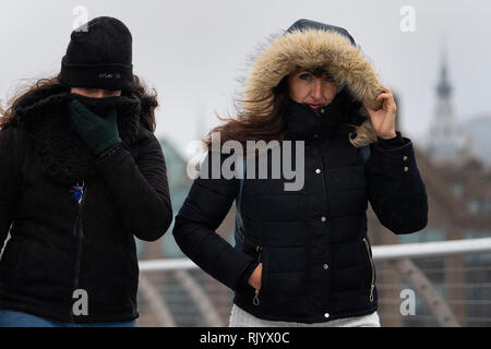 Les touristes bravent les forts vents et la pluie sur le pont du millénaire au centre de Londres, que Storm Erik a de forts vents à certaines parties du pays. Banque D'Images