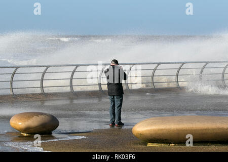 Blackpool, Lancashire. 8 Février, 2019. Météo britannique. Des vents forts sur la promenade de front de mer à marée haute. Les conditions très venteuses comme personnes dodge les vagues sur la tour pointe risquent de complètement trempées dans le vent. /AlamyLiveNews MediaWorldImages : crédit. Banque D'Images