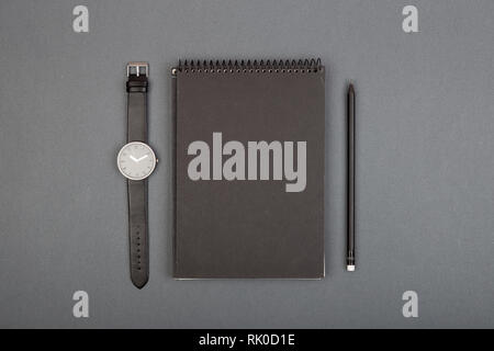 Ordinateur portable blanc spirale, crayon sur fond gris, vue d'en haut Banque D'Images