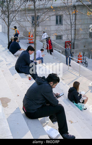 Les gens absorbés dans leurs téléphones portables. Chicago Riverwalk. Banque D'Images