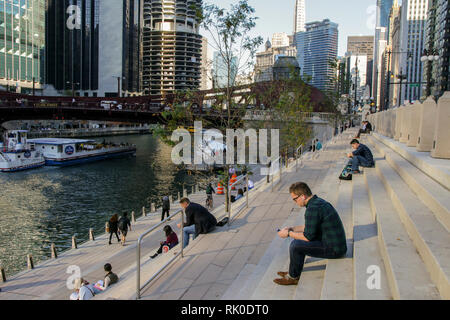 Les gens absorbés dans leurs téléphones portables. Chicago Riverwalk. Banque D'Images