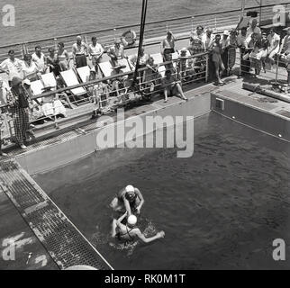 Années 1950, historiques, les passagers à bord d'un bateau à vapeur Union-Castle regardant leurs compagnons de lecture d'un jeu de la piscine. Banque D'Images