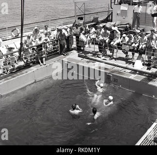 Années 1950, historiques, les passagers à bord d'un bateau à vapeur Union-Castle regardant leurs compagnons de lecture d'un jeu de la piscine. Banque D'Images