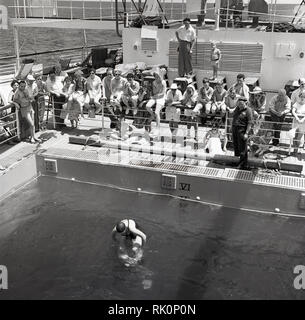 Années 1950, historiques, les passagers à bord d'un bateau à vapeur Union-Castle regardant leurs compagnons de lecture d'un jeu de la piscine. Banque D'Images