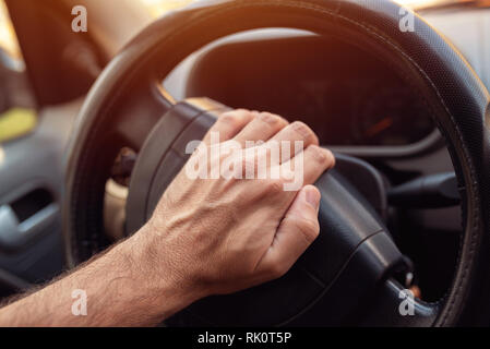 Pilote nerveux poussant klaxon de voiture sur volant Banque D'Images