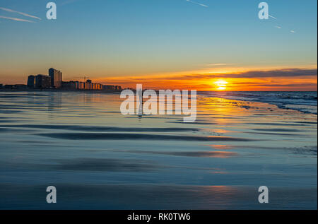 La silhouette d'un homme marchant sur la plage de la mer du Nord d'Ostende au coucher du soleil, Flandre occidentale, Belgique. Banque D'Images