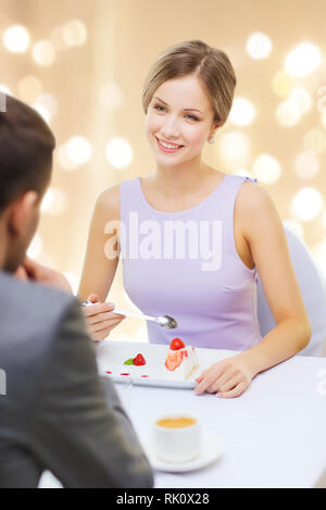 Femme recherche homme à manger un gâteau et au restaurant Banque D'Images