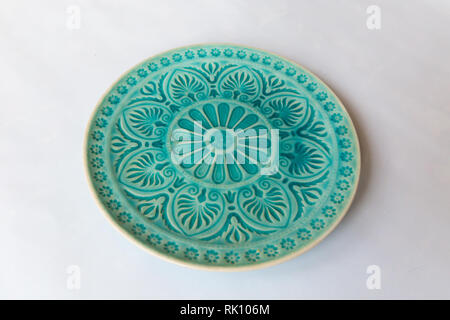 Une plaque ronde avec vert floral et motif de ligne sur fond blanc Banque D'Images