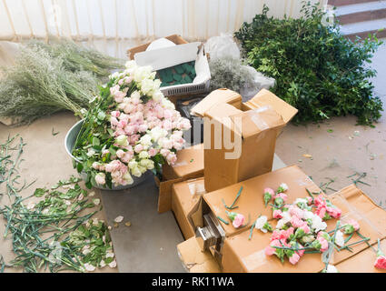 Les préparatifs pour les arrangements floraux - fleurs et feuillages dans des boîtes de carton en attente d'être utilisés pour les décorations de mariage Banque D'Images