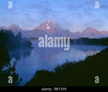 USA, Wyoming, Grand Teton National Park, le brouillard du matin s'attarde à la base du Mt. Moran qui reflète dans la Snake River d'Oxbow Bend. Banque D'Images