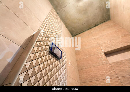 Reconstruction de l'inachevé ou salle de toilettes avec des carreaux en céramique mosaïque géométrique beige installé sur les murs, place pour le lavabo et baignoire. Une faible Banque D'Images