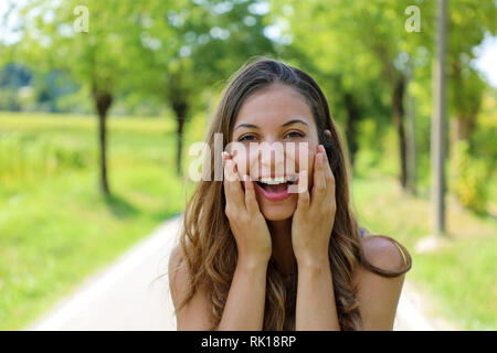 Beautiful happy smiling woman holding her face with mains outdoor Banque D'Images