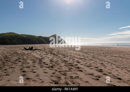 Une plage vide où le sable mène à une montagne et l'océan de l'eau dans l'arrière-plan Banque D'Images