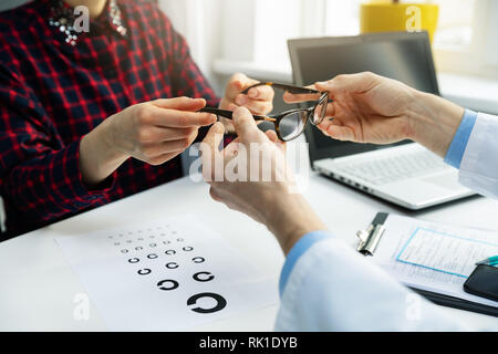 Optométriste visiter - femme obtenir son nouveau bureau de l'opticien à lunettes Banque D'Images
