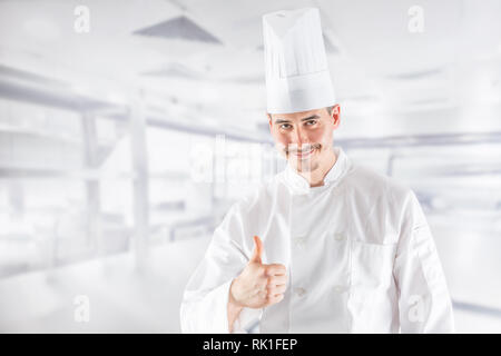 Chef professionnel dans une cuisine de restaurant montrant gestue Thumbs up. Banque D'Images