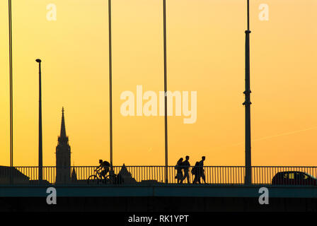 Silhouettes de personnes traversant le pont Banque D'Images