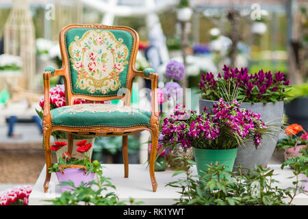 Fauteuil en bois avec de belles fleurs du tissu et à l'arrière-plan Banque D'Images