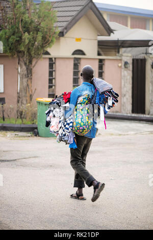 Emplois urbains - un colporteur vente de vêtements dans les rues de Lagos Banque D'Images