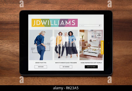 Le site internet de JD Williams est considéré sur une tablette iPad, qui repose sur une table en bois (usage éditorial uniquement). Banque D'Images