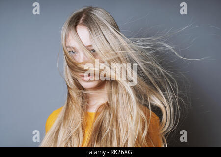 Femme blonde avec de longs cheveux ébouriffés balayé par Banque D'Images