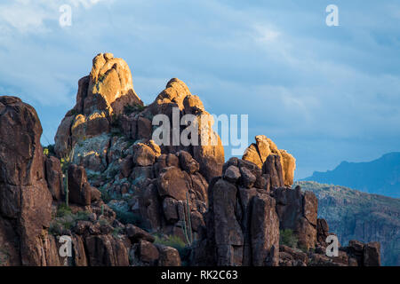 Le soleil qui met en évidence les formations rocheuses sur le haut d'un pic les Superstition Mountains, Arizona Banque D'Images